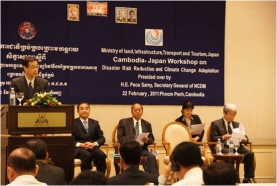 奥村企画官による挨拶（壇上左からタイシエン副知事、サミー事務局長、新井理事）